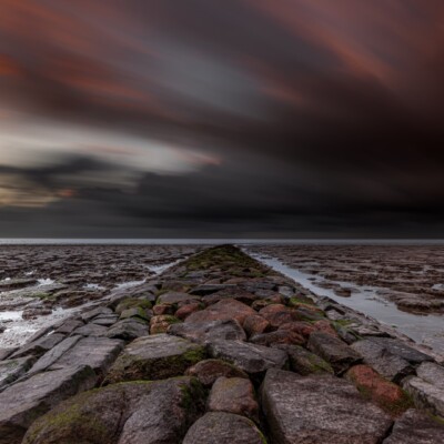 Dijk van stenen in de zee