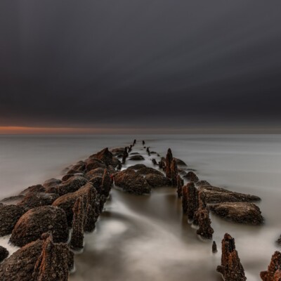 Dijk van stenen in een mistige waddenzee